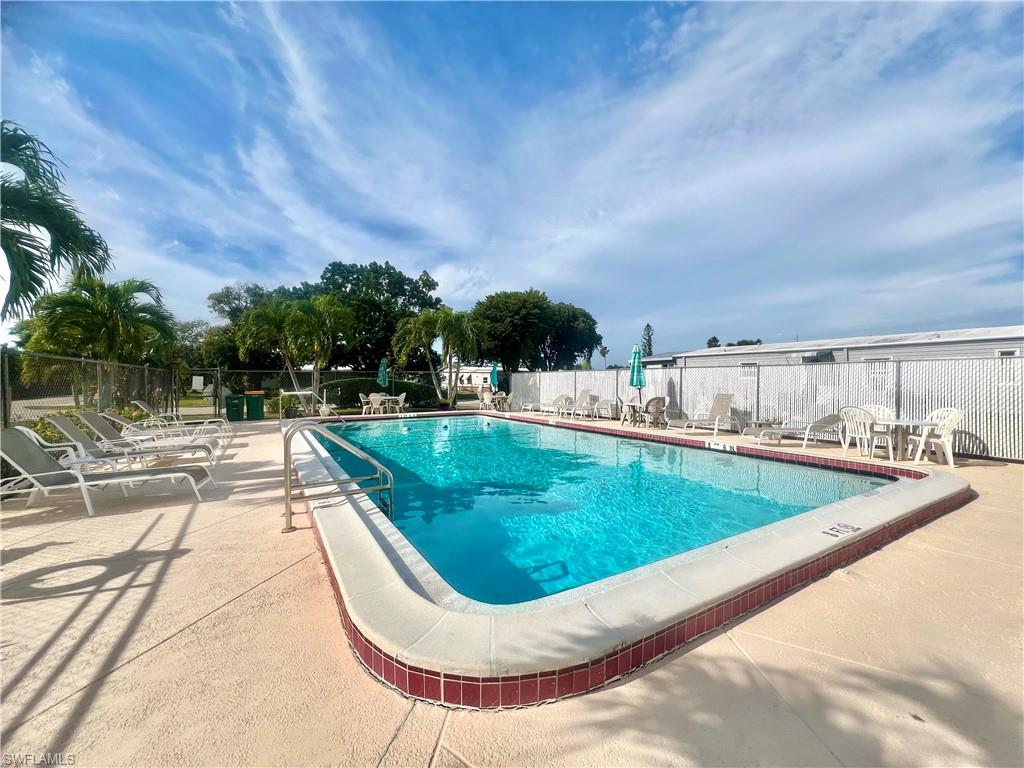 273 Cape Sable Drive Naples, FL 34104 - Photo 47 of 49 a view of a swimming pool with an outdoor seating and a yard