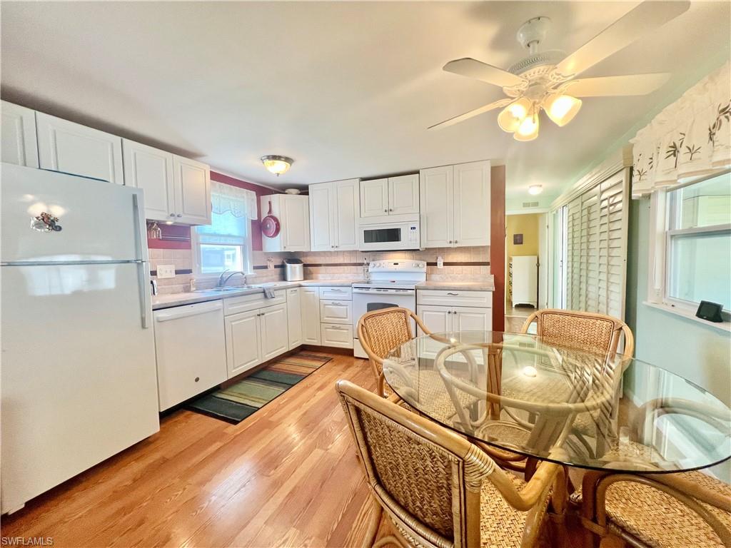 273 Cape Sable Drive Naples, FL 34104 - Photo 6 of 49 a kitchen with kitchen island granite countertop a sink cabinets stainless steel appliances and a dining table