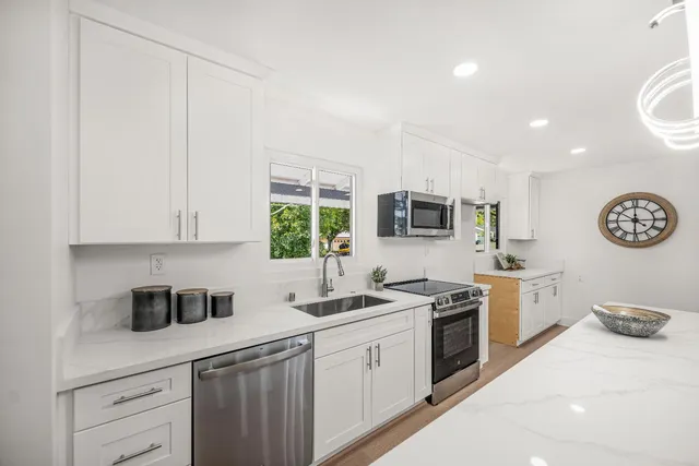 a kitchen with stainless steel appliances granite countertop a sink stove and refrigerator