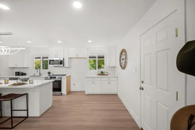 a kitchen with kitchen island granite countertop lots of counter top space and stainless steel appliances