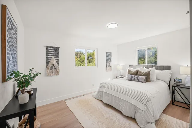 a bedroom with a bed and a potted plant