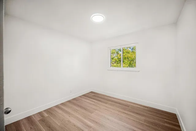 a view of room with window and wooden floor