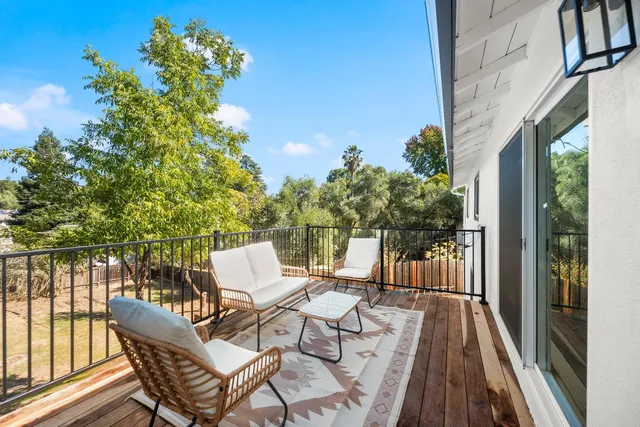 a view of balcony with furniture and garden