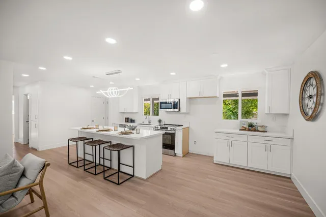 a kitchen with a stove a sink a dining table and chairs