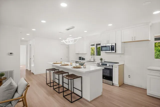 a kitchen with stainless steel appliances granite countertop a sink stove and refrigerator