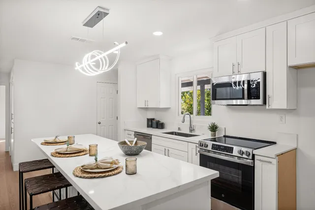 a kitchen with a table chairs stove and microwave
