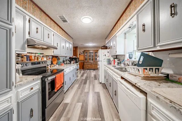 a kitchen with stainless steel appliances granite countertop lots of counter top space and wooden floor