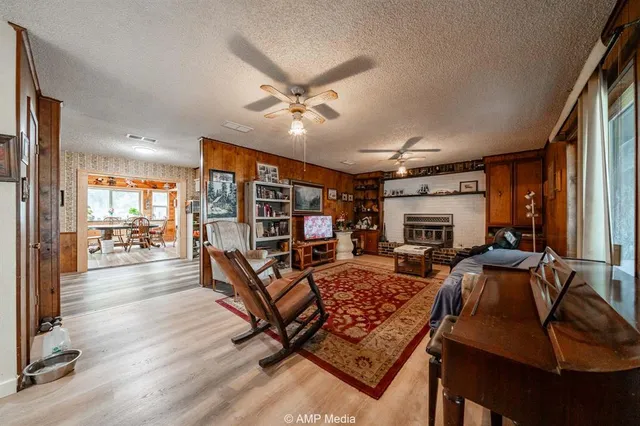 a living room with furniture a fireplace and a large window