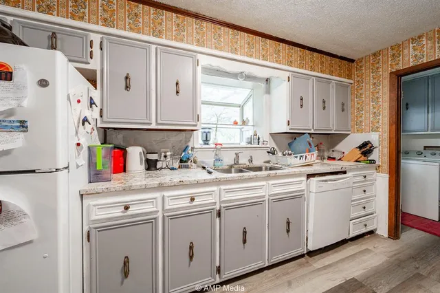 a kitchen with white cabinets and white appliances