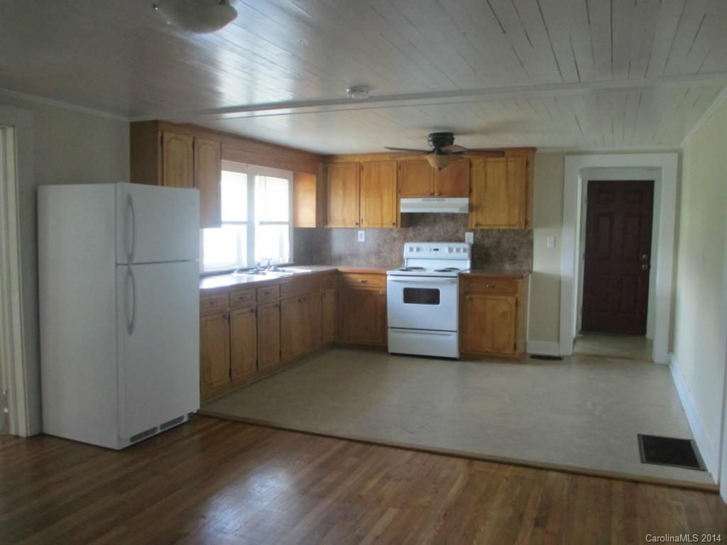 4091 Flat Creek Road Lancaster, SC 29720 - Photo 6 of 19 a kitchen with stainless steel appliances a refrigerator a sink dishwasher a stove and white cabinets with wooden floor