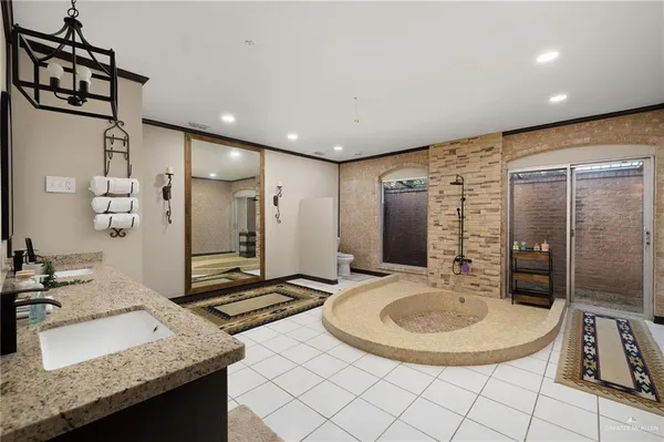 a bathroom with a granite countertop sink a mirror and shower