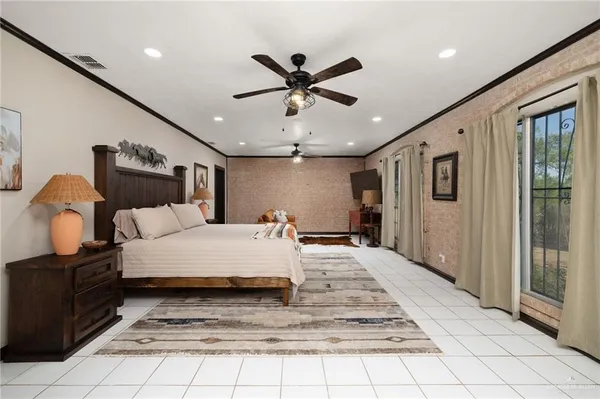 a large bedroom with a bed and glass walk in closet