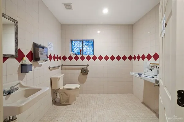 a bathroom with a sink mirror and toilet
