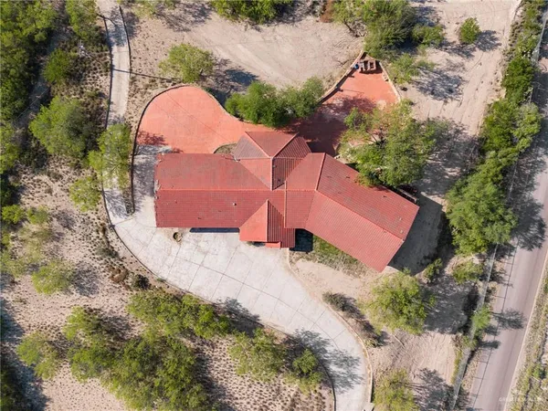 an aerial view of a house with a yard and a large tree