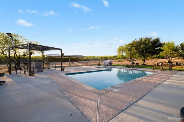 a view of a swimming pool with an outdoor seating and a yard