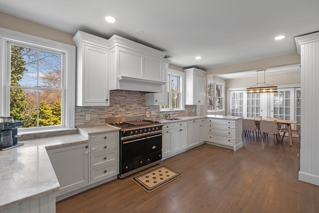 90 Puritan Road Swampscott, MA 01907 - Photo 16 of 42 a kitchen with stainless steel appliances kitchen island granite countertop a stove a sink a refrigerator and white cabinets