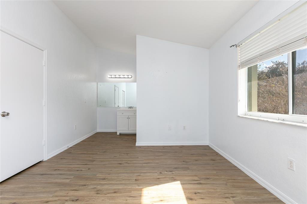 159 Hidden Ct Road, Unit I49 Hollywood, FL 33023 - Photo 11 of 21 a view of an empty room with wooden floor and a window