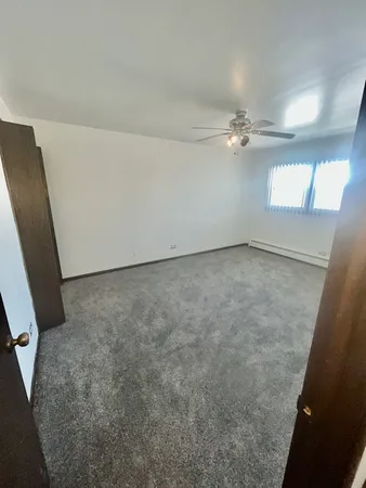 en empty room with windows and fan