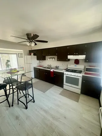 a kitchen with stainless steel appliances a stove a sink and white cabinets