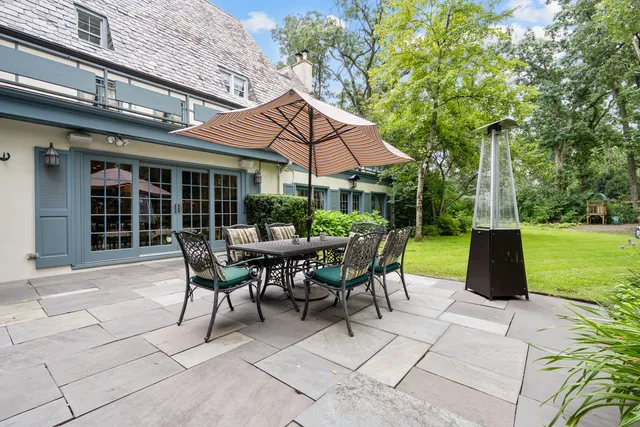 a view of a patio with table and chairs under an umbrella