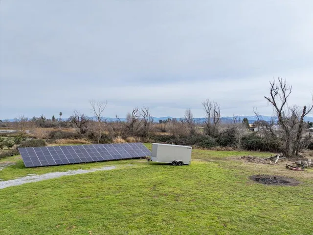 a view of a patio with table and chairs potted plants and a large tree