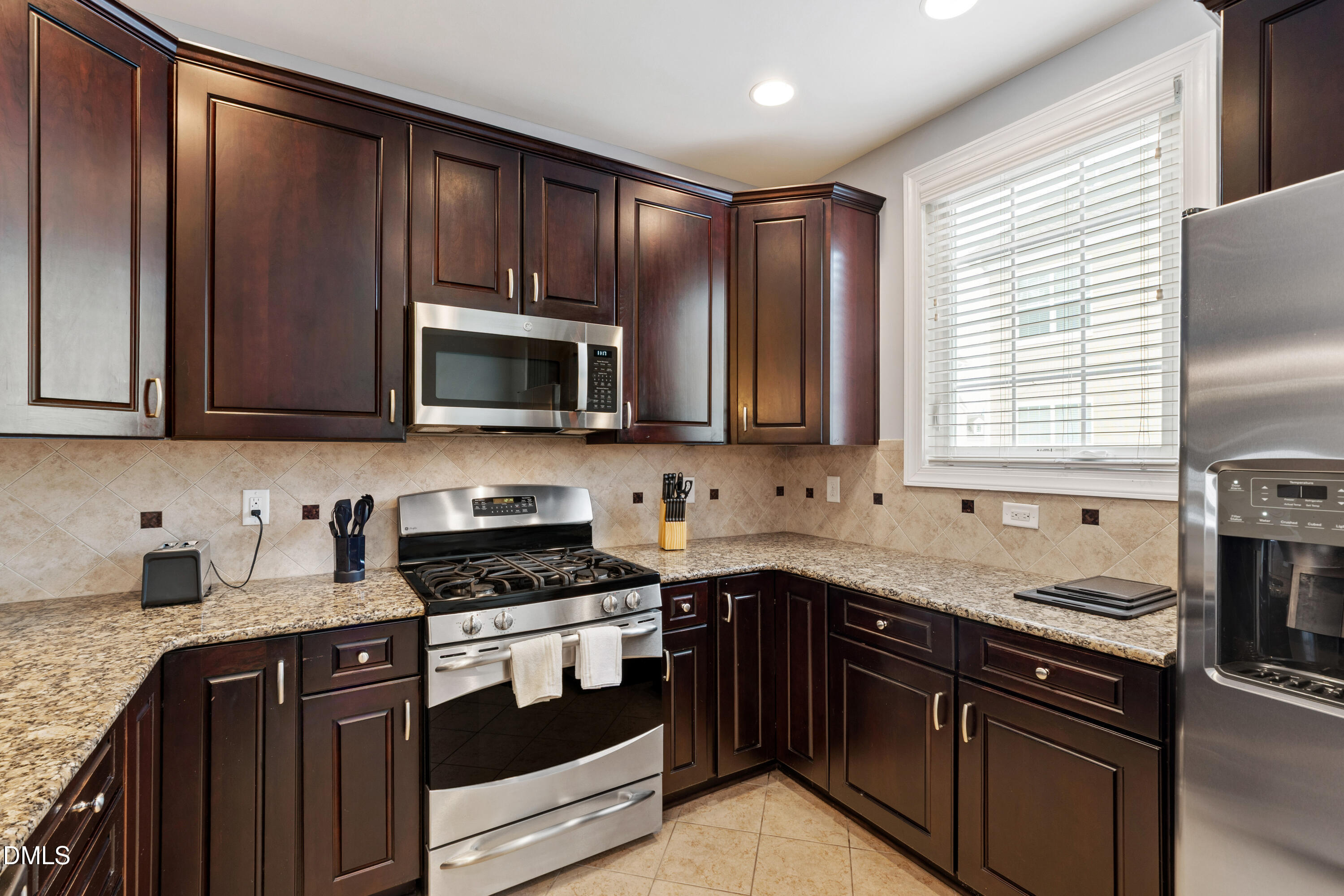 10321 Sablewood Drive, Unit 108 Raleigh, NC 27617 - Photo 12 of 41 a kitchen with granite countertop wooden cabinets stainless steel appliances a sink and a window