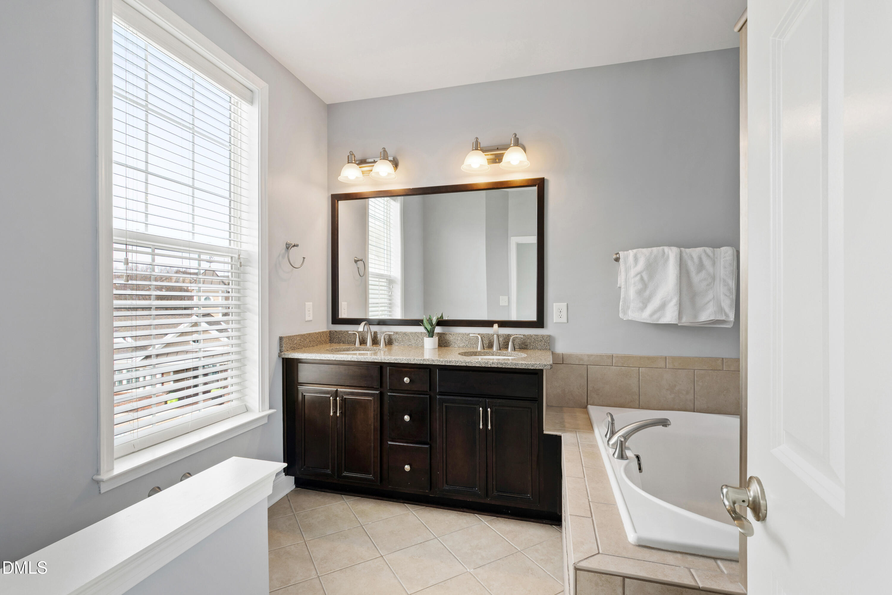 10321 Sablewood Drive, Unit 108 Raleigh, NC 27617 - Photo 21 of 41 a bathroom with a tub sink and mirror