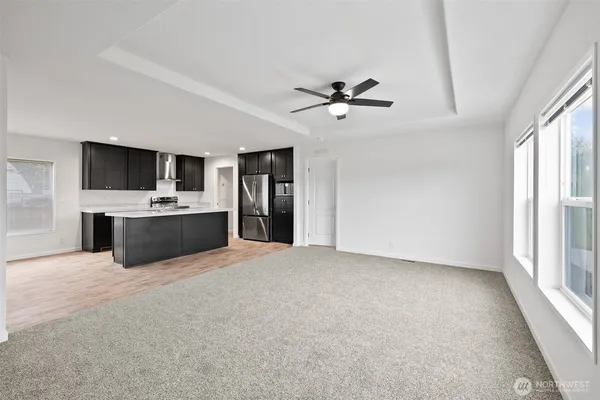 a view of an empty room with a window and a kitchen