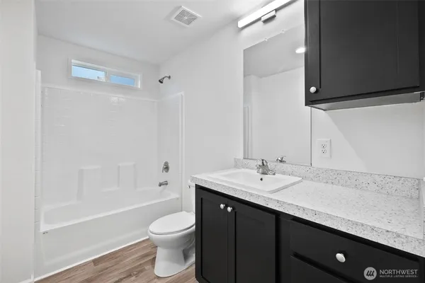a bathroom with a granite countertop sink toilet and shower