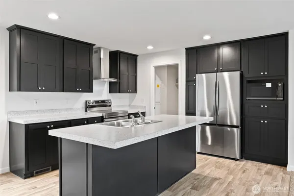a kitchen with kitchen island a sink stainless steel appliances and cabinets