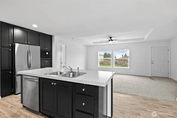 a kitchen with stainless steel appliances granite countertop a sink and a refrigerator