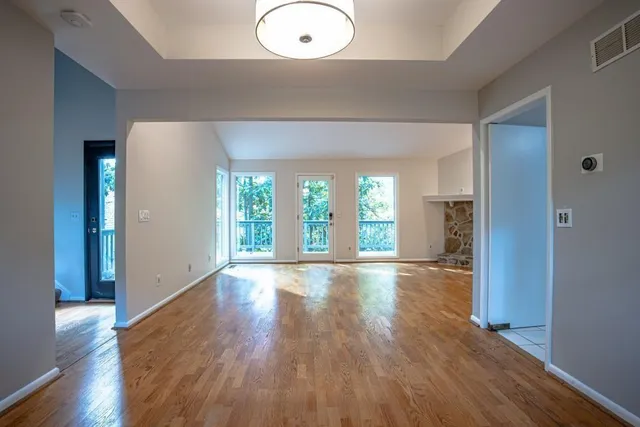 an empty room with wooden floor and windows