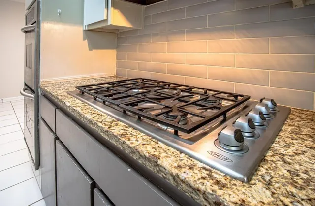 a stove top oven sitting inside of a kitchen