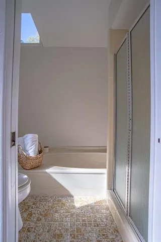 a bathroom with a granite countertop bathtub and toilet