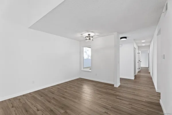 a view of an empty room with wooden floor