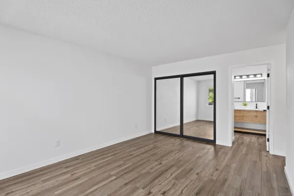 a view of empty room with wooden floor
