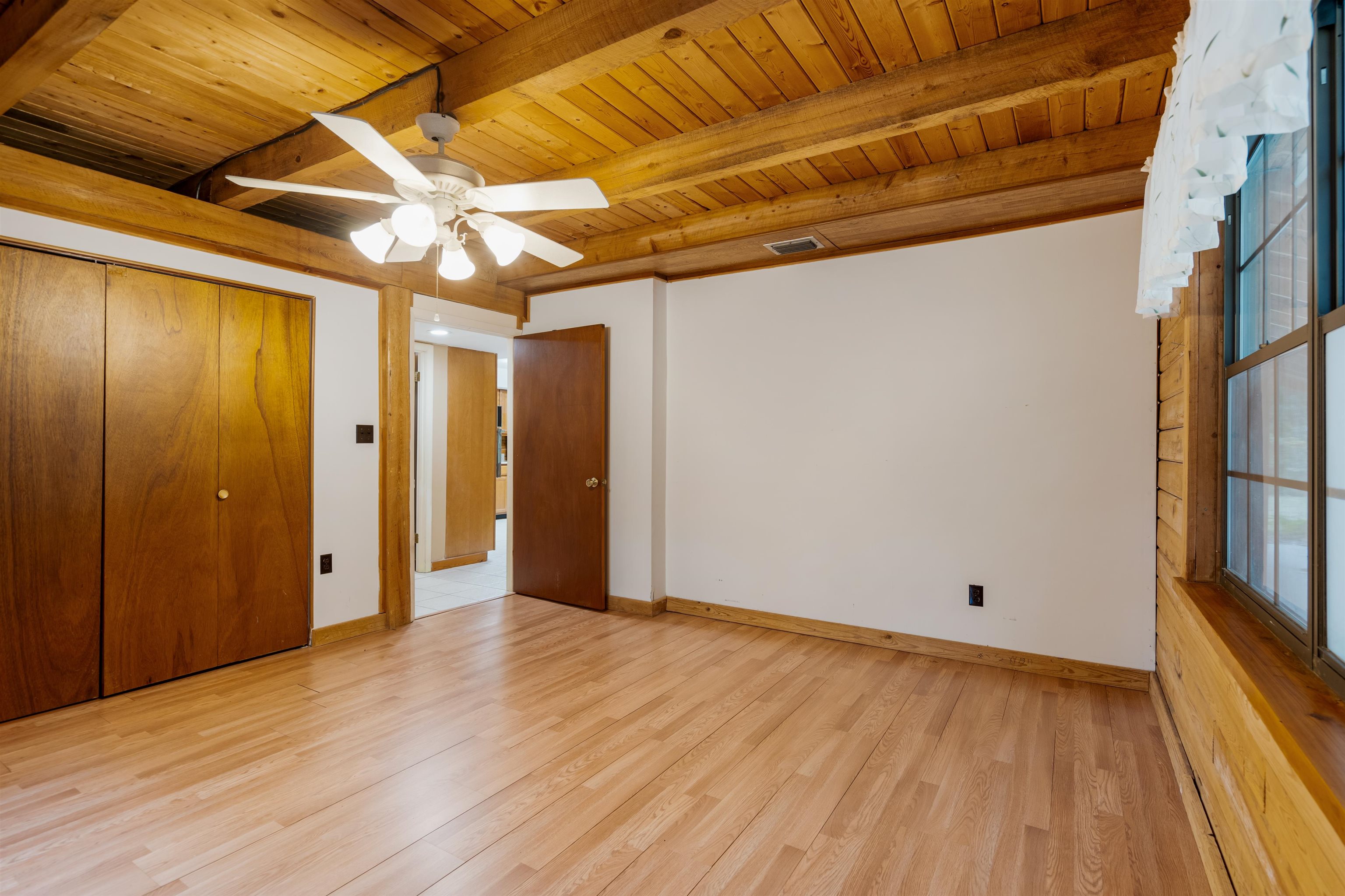 5850 Capo Island Road St. Augustine, FL 32095 - Photo 17 of 39 a view of an empty room with wooden floor and a window