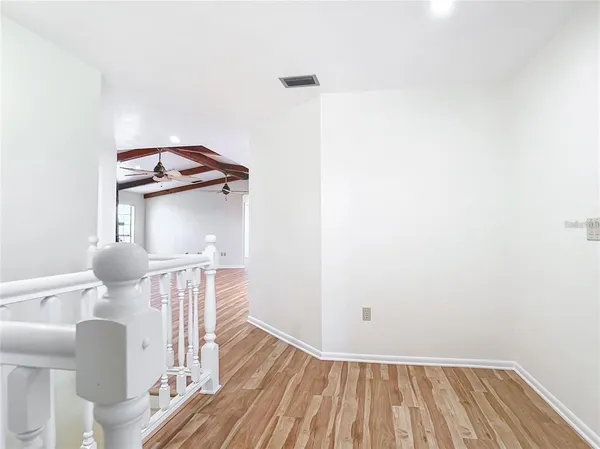 a view of a room with wooden floor and fan