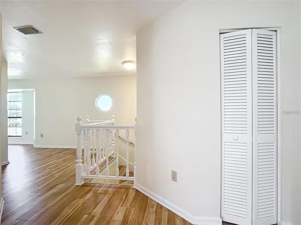 a view of empty room with wooden floor fireplace and fan
