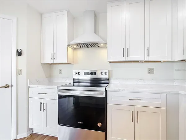 an empty room with wooden floor ceiling fan and windows