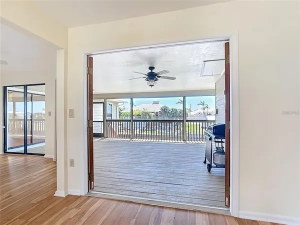 a view of a room with wooden floor and a ceiling fan