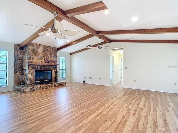 a view of a big room with wooden floor and a ceiling fan
