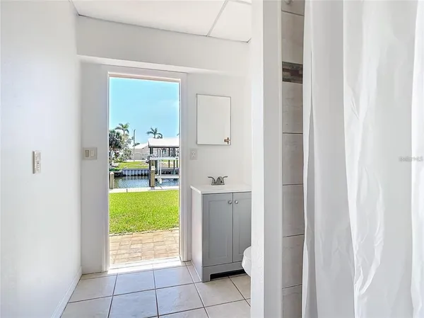 an aerial view of ocean and residential houses with outdoor space