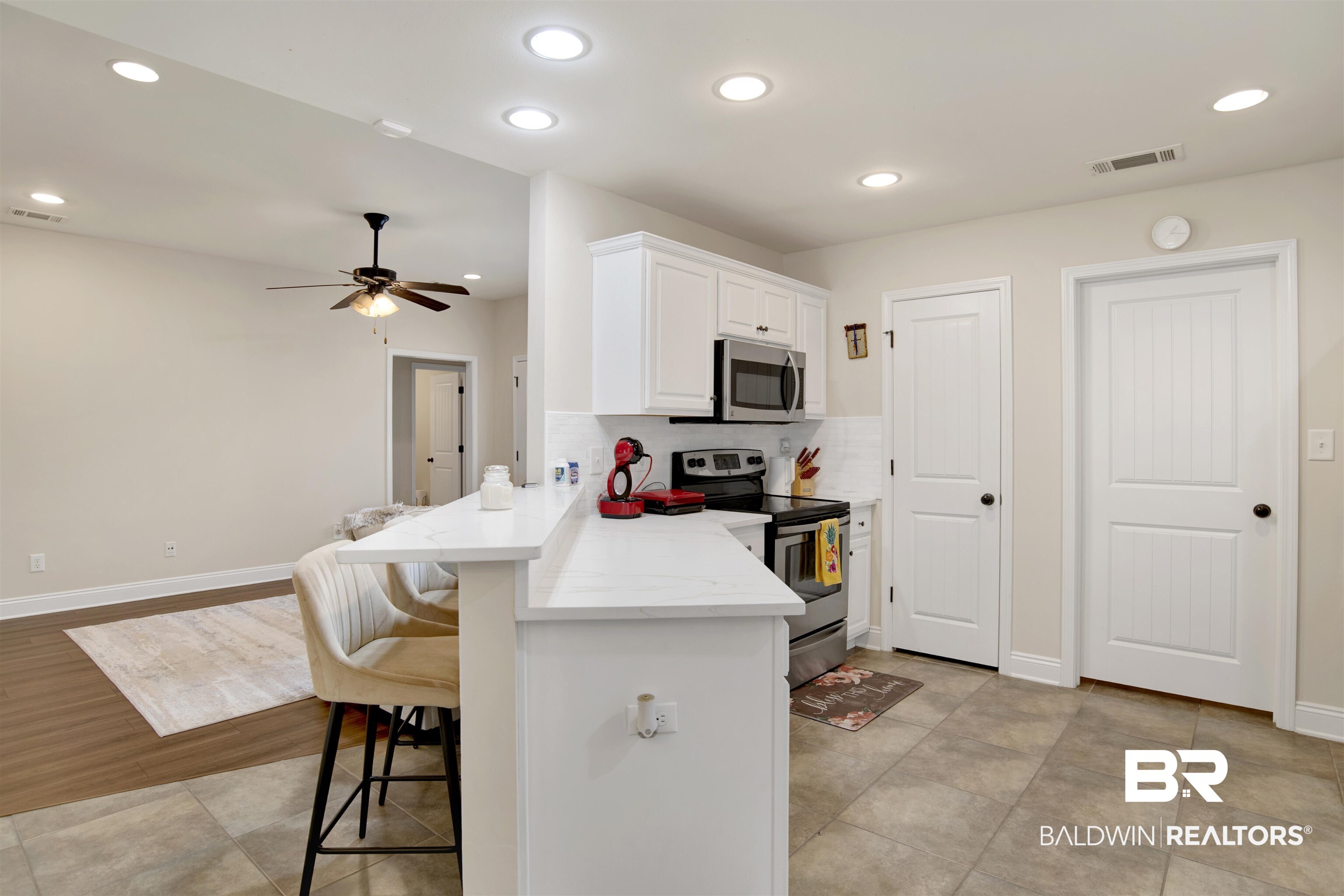 8542 Three Dean Way Mobile, AL 36695 - Photo 9 of 26 Kitchen with appliances with stainless steel finishes, a breakfast bar, white cabinetry, a peninsula, and ceiling fan