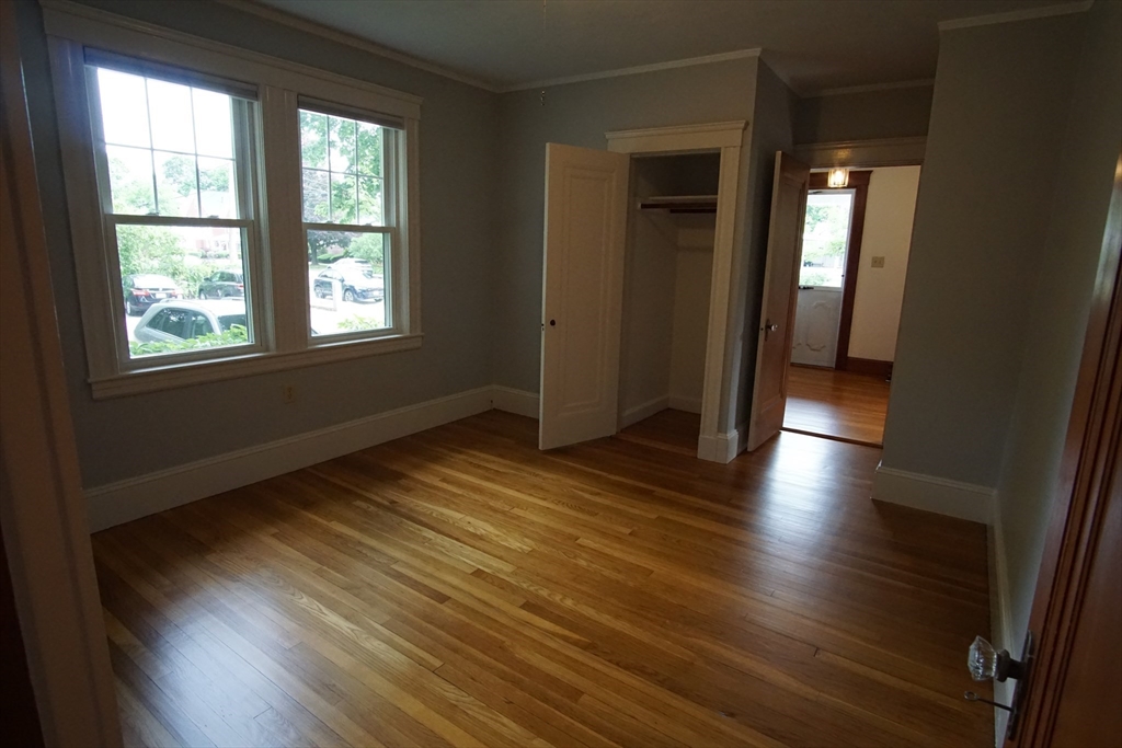 754 Massachusetts Avenue, Unit 1 Lexington, MA 02421 - Photo 17 of 17 an empty room with wooden floor and windows