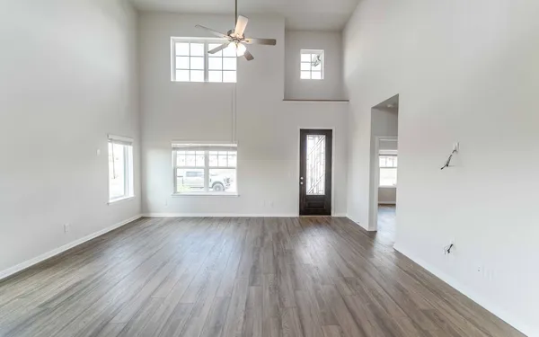 an empty room with wooden floor and windows