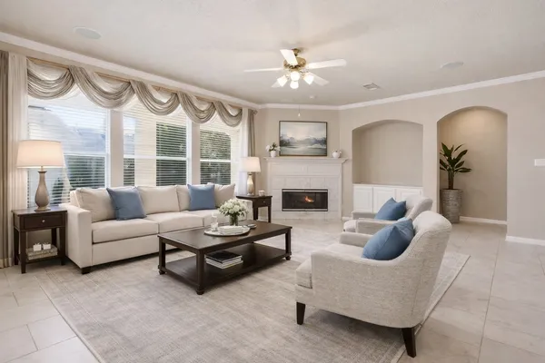 a bedroom with a large bed and a chandelier fan