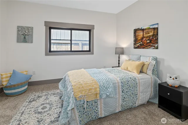 a bedroom with a bed and painting on the wall