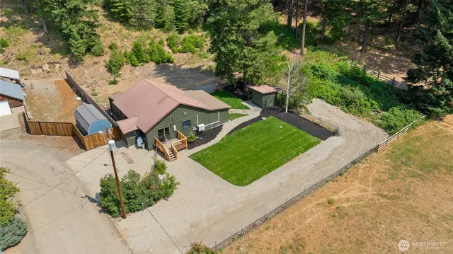 an aerial view of a house with garden space and trees