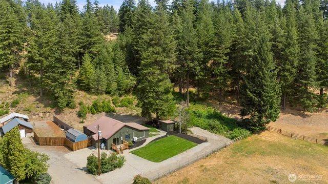 an aerial view of a house with yard and green space